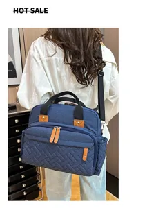 Large capacity stylish blue diaper bag with multiple pockets worn by a woman outdoors.