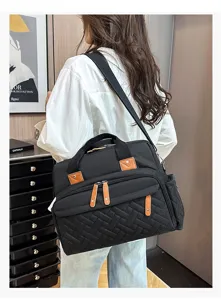 Detailed back view of a stylish black large capacity diaper bag with quilted texture