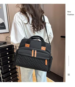 Stylish black quilted diaper bag with multi-pocket design shown from a back view