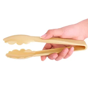 Detailed view of a hand holding ergonomic beige plastic food tongs for kitchen use