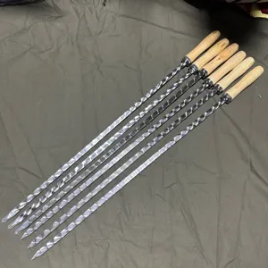 Detail of six stainless steel BBQ skewers with twisted blades and wooden handles