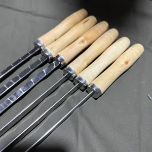 Detailed close-up view of stainless steel BBQ skewers with ergonomic wooden handles