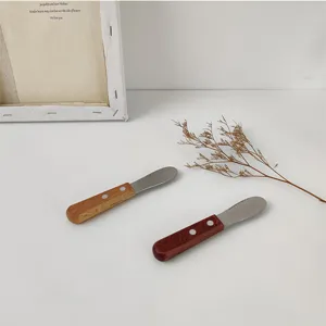 Detailed view of retro wooden handle butter knives with polished stainless steel blades