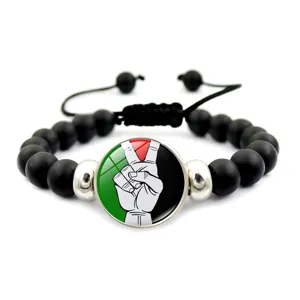 Dettaglio del charm della bandiera palestinese su bracciale nero a perle regolabile