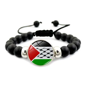 Dettaglio del ciondolo con bandiera palestinese su bracciale di perline nere regolabile