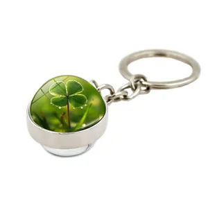Detailed macro view of a silver keychain featuring a realistic four-leaf clover crystal ball