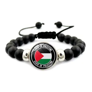 Dettaglio del cabochon bandiera Palestina su bracciale intrecciato regolabile nero