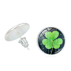 Detail view of silver stud earrings with a green clover glass cabochon design
