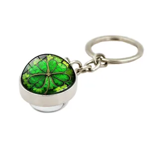 Macro view of the lucky four-leaf clover design under a clear glass dome on a metal keychain
