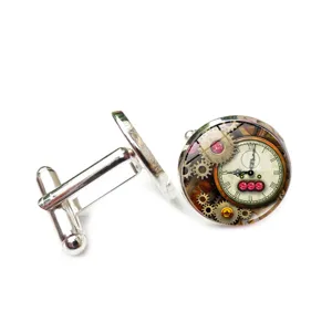 Close-up detail of steampunk clockwork gear cufflinks with vintage glass cabochon finish.