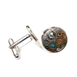 Detailed view of silver steampunk cufflinks featuring mechanical gears and a raven motif