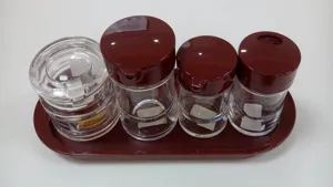 Detail of clear acrylic seasoning bottle set with burgundy lids and tray