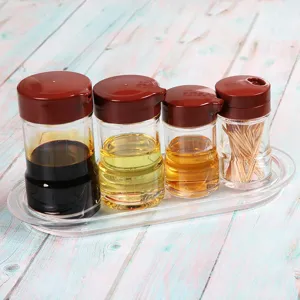 Transparent acrylic oil and vinegar bottle set with brown lids on a clear oval tray