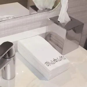Nahaufnahme weißer Papierservietten mit grauem Blumenmuster für die gehobene Gastronomie
