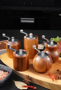 Acacia wood manual pepper and spice grinder set, detailed view with kitchen seasoning tools.