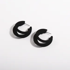 Detailed view of elegant black flocked double-hoop earrings with soft velvet finish