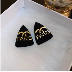 Vintage black flocked triangular stud earrings featuring gold-tone PARIS text design