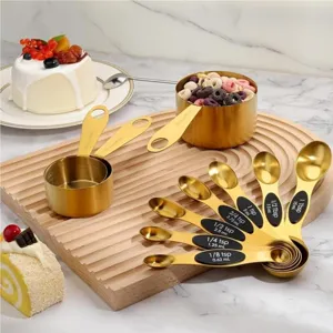 Stainless steel measuring cups and spoons set, gold baking kitchen tools, precise measurements.