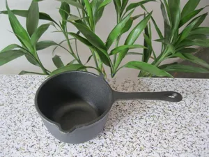 Detail view of 16cm cast iron mini milk pot with pour spout and long handle