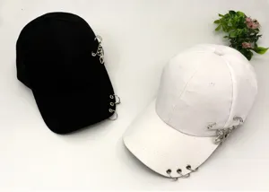 Detailed view of casual hip-hop baseball caps with metal rings, safety pins and star pendants.