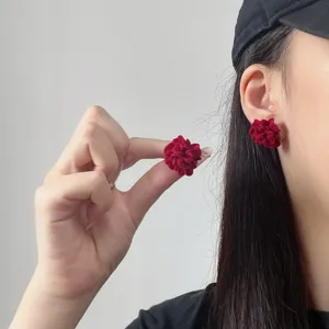 Detailaufnahme der eleganten roten 3D-Blumen-Ohrstecker mit weicher Samt-Textur