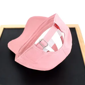 Detailed macro view of a pink baseball cap showing the adjustable metal buckle back strap