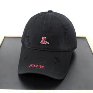 Detailed shot of a black distressed baseball cap featuring red L embroidery and brim text.