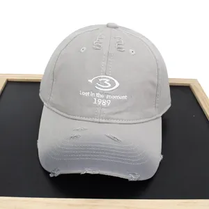 Detailed view of a distressed gray baseball cap with white Lost in the moment 1989 embroidery