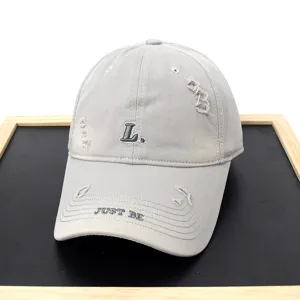 Grey distressed baseball cap with L embroidery and casual streetwear style close-up shot.
