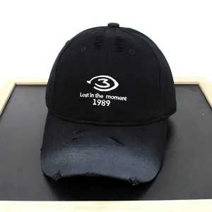 Close-up of distressed black baseball cap with white embroidery Lost in the moment 1989