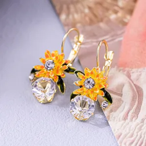 Detailed macro view of elegant sunflower earrings with yellow enamel and sparkling crystals