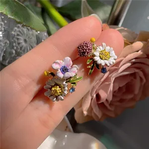 Close-up detail of forest-style floral earrings with enamel flowers and sparkling crystals