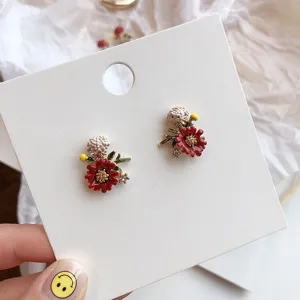 Macro detail of elegant forest style red flower stud earrings with sparkling rhinestones