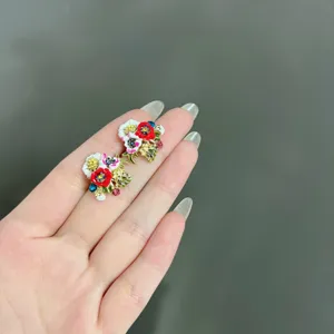 Close-up of elegant forest style floral stud earrings featuring colorful crystal accents
