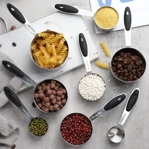 Close-up detail of stainless steel measuring cups set filled with colorful grains and coffee