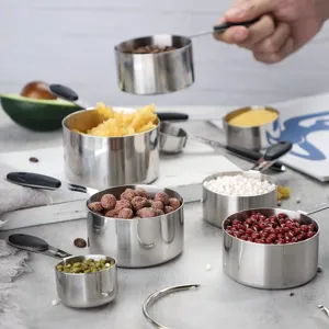 Detailed view of stainless steel measuring cups set with different dry ingredients