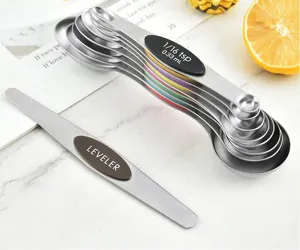 Detail view of stacked stainless steel measuring spoons and a metal leveler tool
