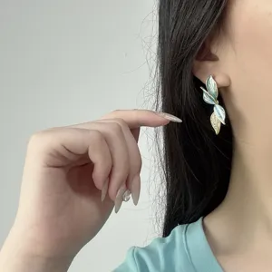 Dettaglio di un orecchino elegante a forma di foglia con cristalli sull'orecchio