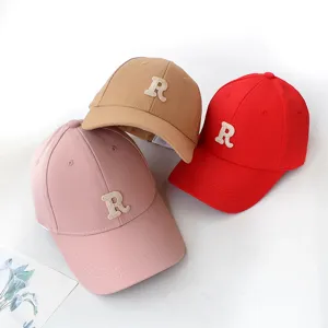 Three colorful baseball caps with embroidered R letter detail on white background