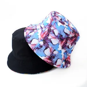 Reversible bucket hat with abstract print and solid black side for outdoor sun protection.