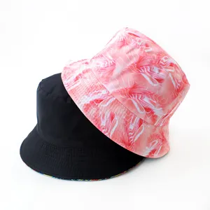 Vue rapprochée de bobs réversibles avec un côté noir uni et un imprimé rose abstrait.