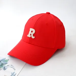 Detail of red baseball cap with embroidered white R patch on front crown