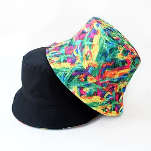 Reversible bucket hat with abstract digital print and solid black side for casual outdoor sun protection.