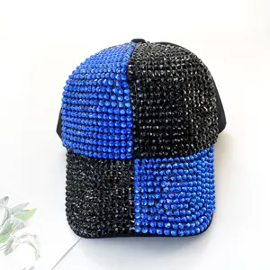Primer plano de gorra de béisbol con pedrería negra y azul, detalles de cristales brillantes.