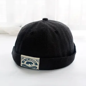 Detailansicht einer schwarzen retro docker mütze, trendiger melon hat mit vintage patch.