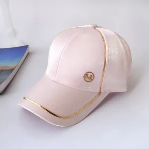 Pink baseball cap with metallic gold piping and M logo, stylish sun protection hat for women.