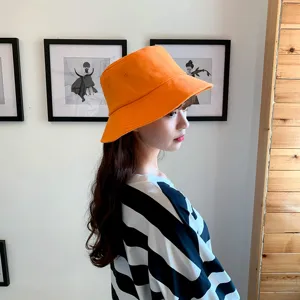 Stylish orange cotton bucket hat for summer sun protection shown on a female model profile