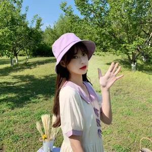 Asian model wearing a lavender Japanese style bucket hat outdoors in a garden