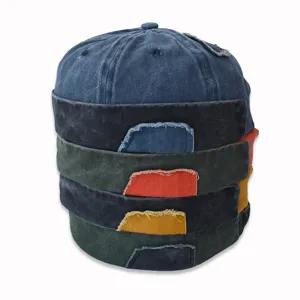 Pila di berretti senza tesa lavati e consumati in stile vintage con vari colori e toppe