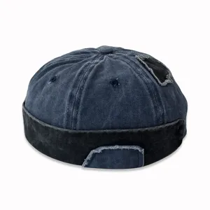 Dettaglio di un cappello docker in denim lavato effetto invecchiato con decorazione